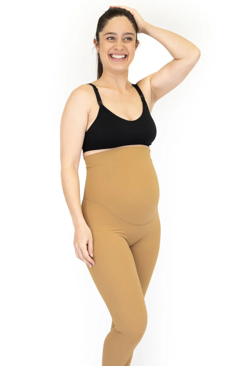 Pregnant woman in black sports bra and tan maternity leggings on final sale