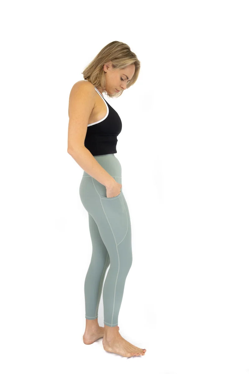 Woman in black tank top and blue leggings for Final Sale, limited sizes available