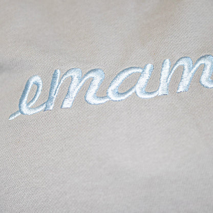 Embroidered cursive text emam on light fabric of cropped sweat maternity activewear