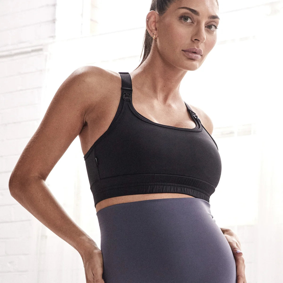 Woman in black Elevate Nursing Sports Bra and gray leggings for active nursing moms