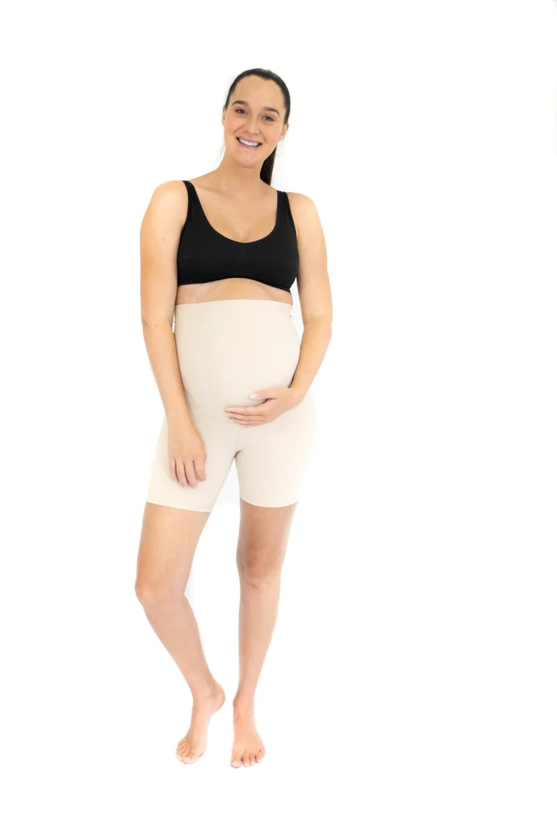 Pregnant woman in black sports bra and white emama Maternity Bike Shorts showcasing style