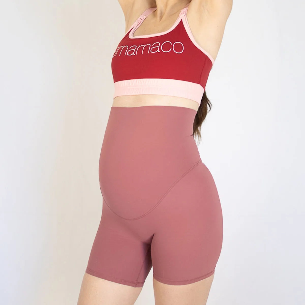 Woman in red sports bra and high-waisted pink Emama Maternity Bike Shorts with pockets