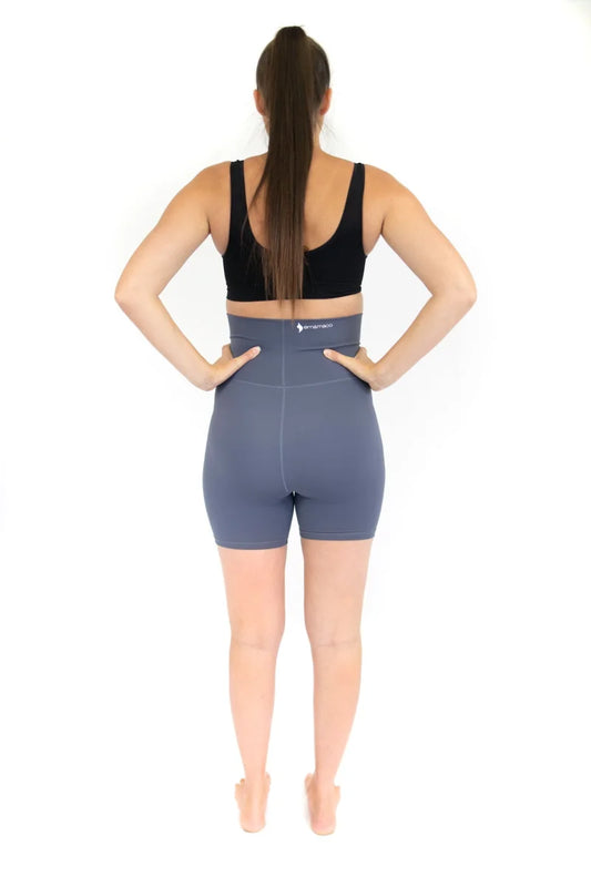 Woman showcasing Emama Maternity Bike Shorts with pockets in blue and black sports bra