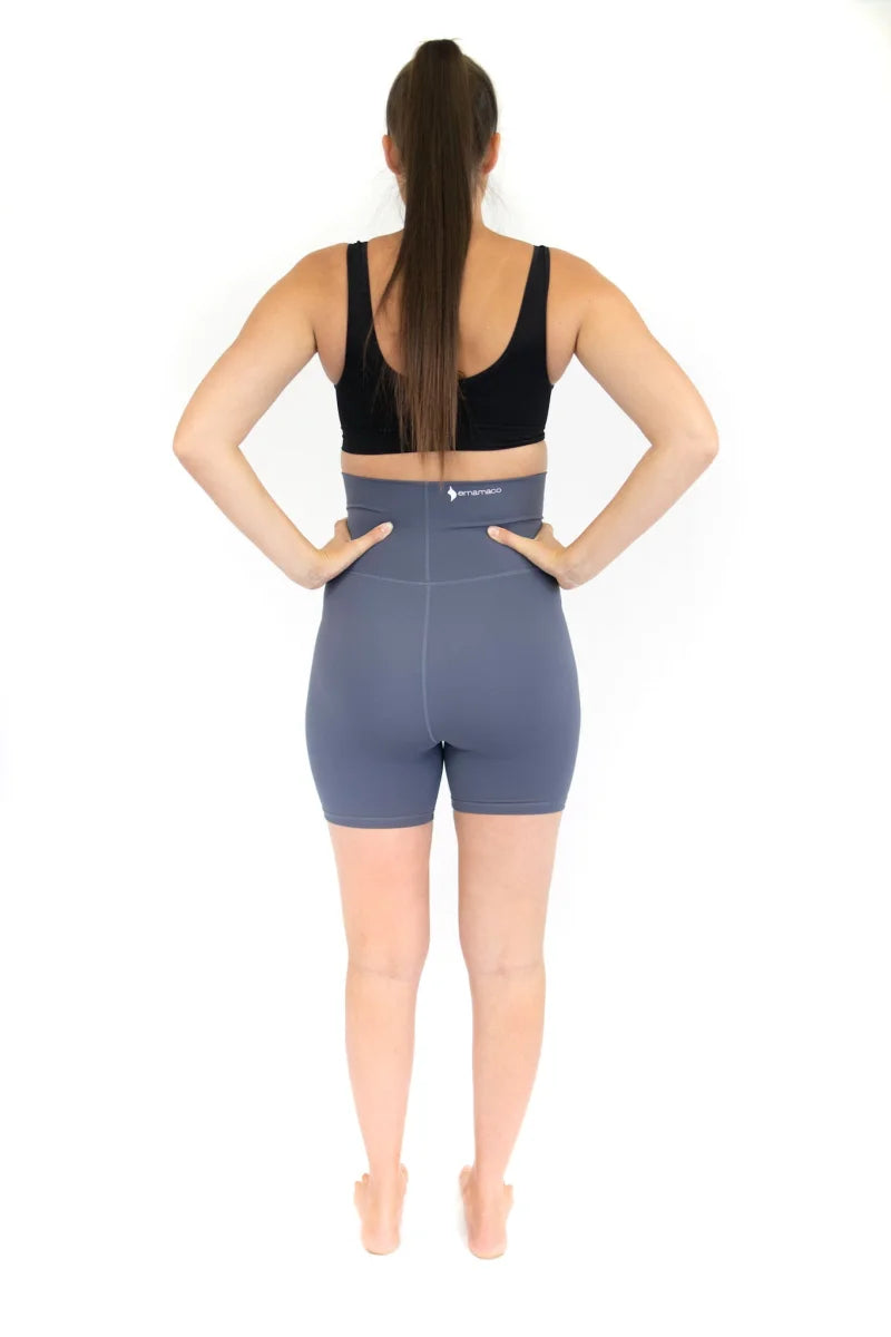 Woman in black sports bra and blue shorts, showcasing emama Maternity Bike Shorts