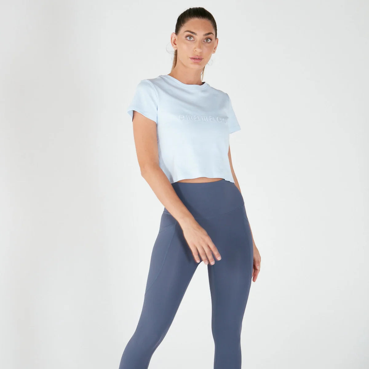 Woman in a loose fitting Emamaco light blue tee and blue-gray leggings outfit