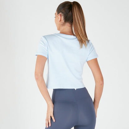 Woman in loose fitting Emamaco light blue tee and navy leggings, viewed from behind