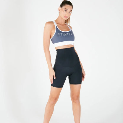 Woman in blue sports bra and black high-waisted shorts for pregnancy recovery