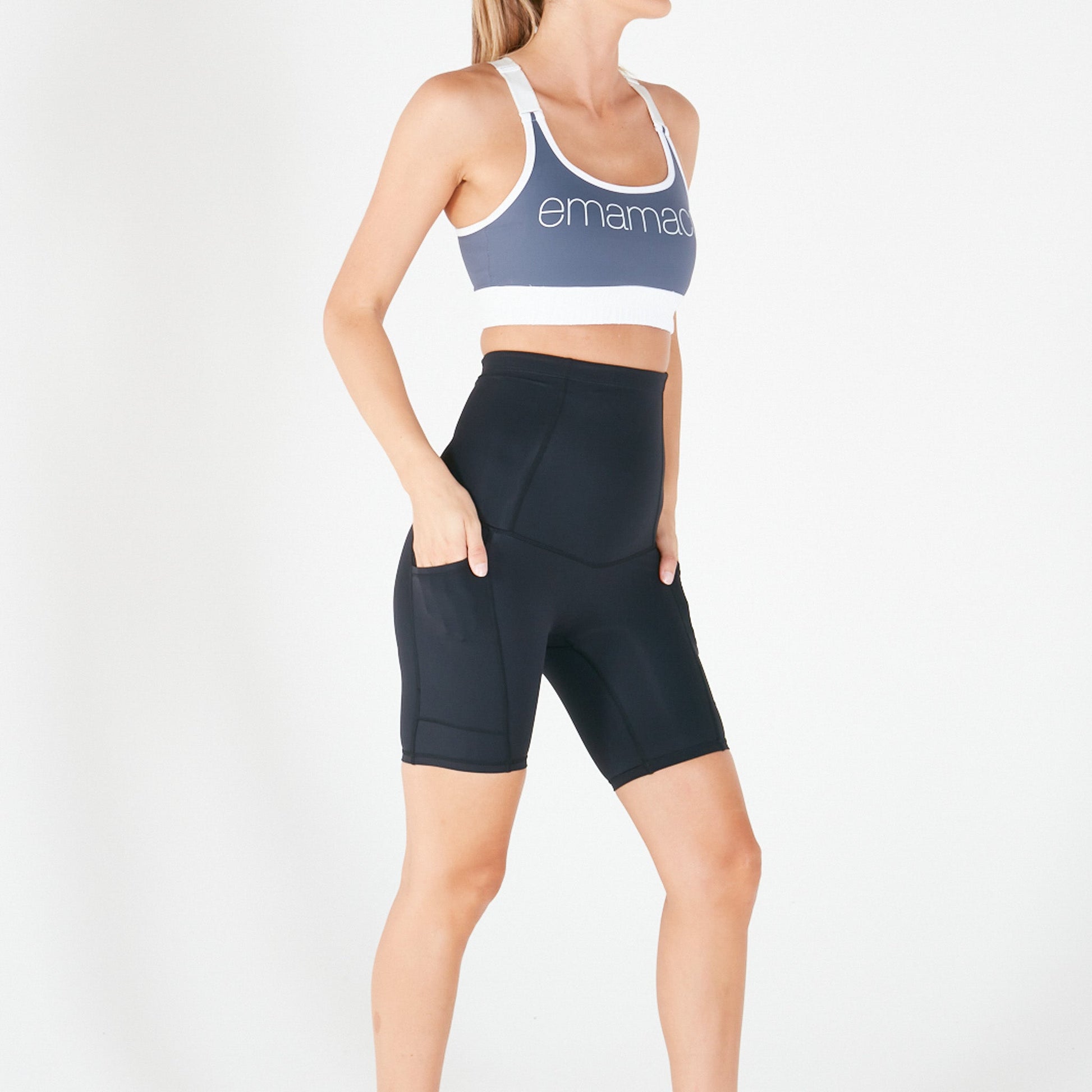 Woman in sports bra and high-waisted shorts, ideal for postpartum recovery with pockets