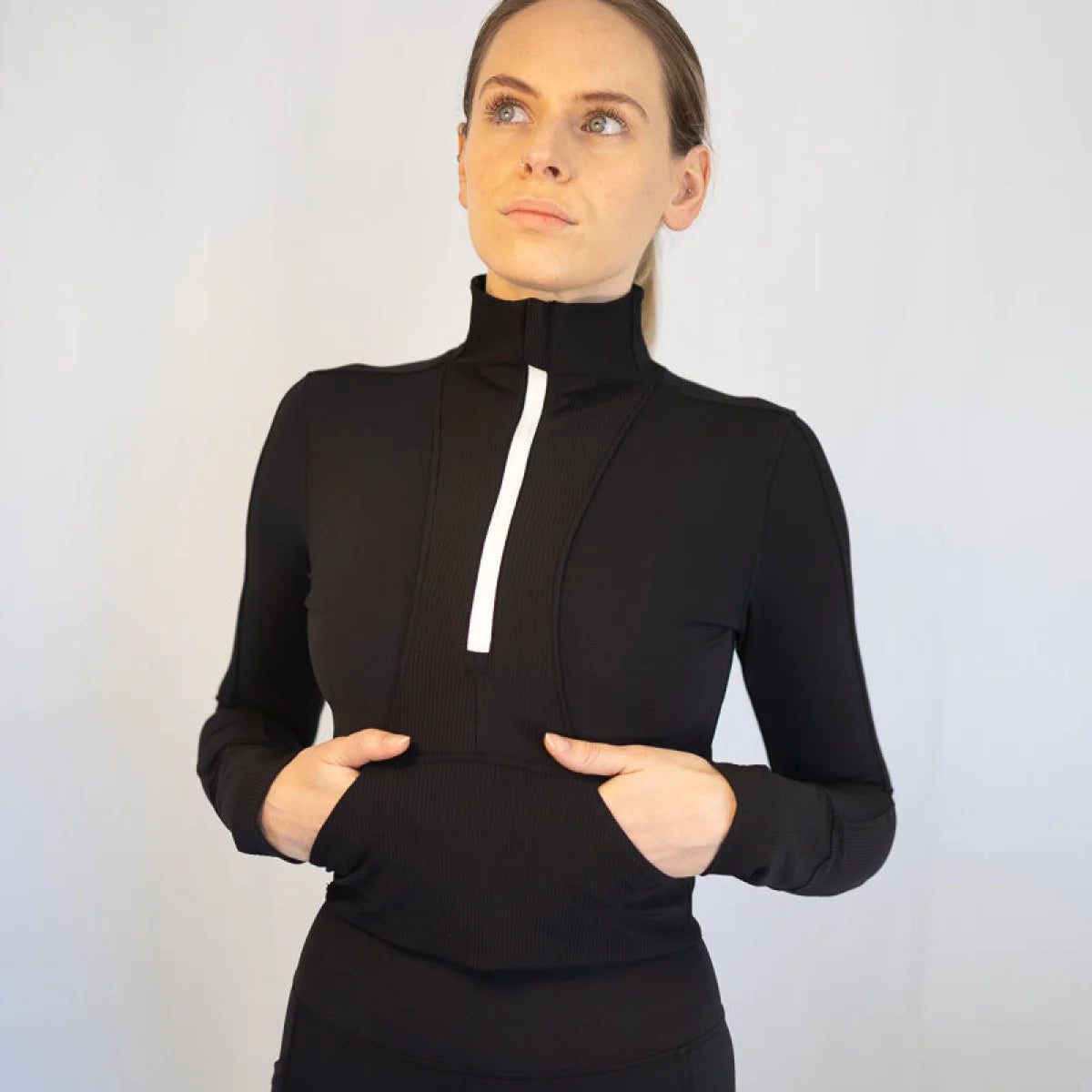 Black turtleneck Rosetta Top with white quarter-zip detail for body hugging sports