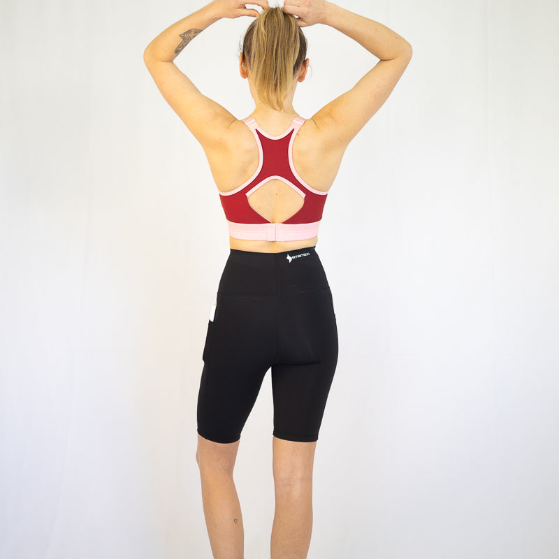 Woman in red sports bra and black long shorts, perfect for pet hair and maternity wear