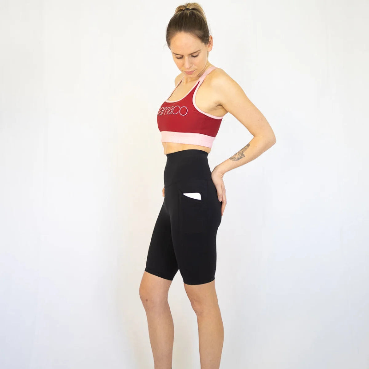 Woman in red sports bra and black long shorts, perfect for maternity and pet hair