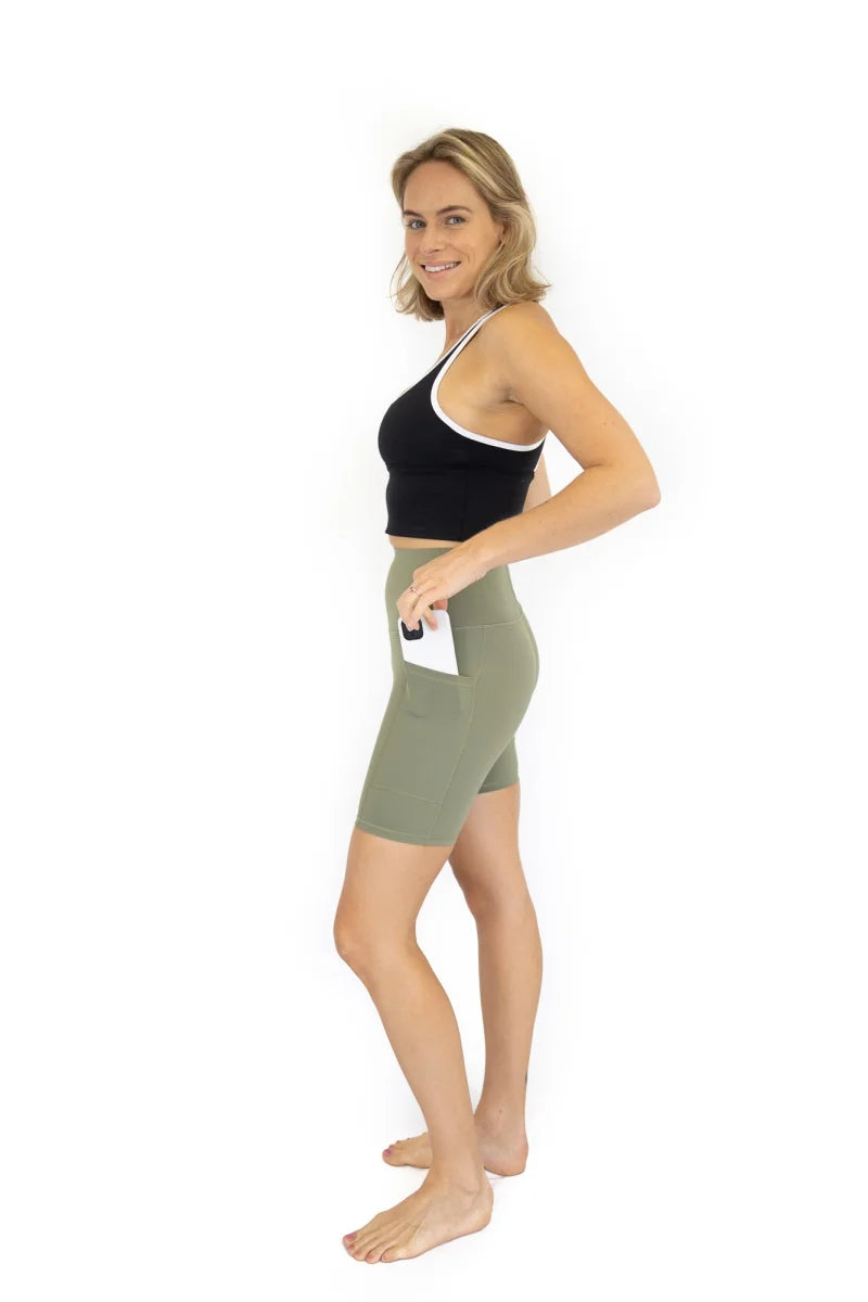 Woman in black crop top and olive green Shaper Move Shorts on final sale