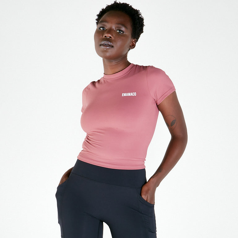 Woman in pink t-shirt and dark pants showcasing Vibe V Long Shorts in Black